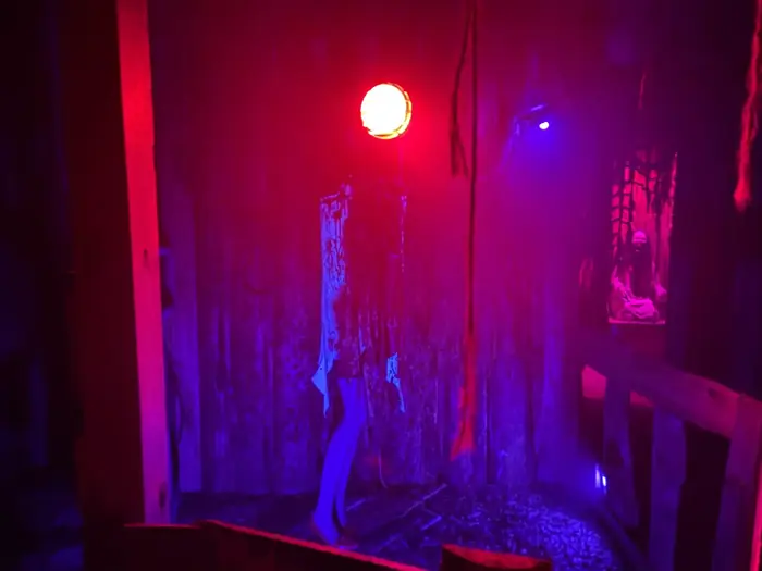 An interior Grimm Grounds scene lit in red and violet