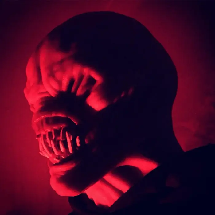 A frightening mask lit from below in red