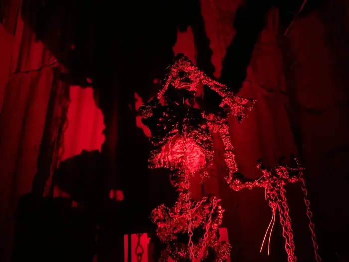 A chained skeletal figure illuminated in red