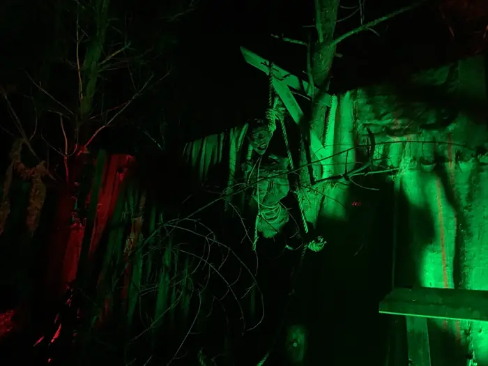 A hanging figure on the nighttime trail illuminated in green